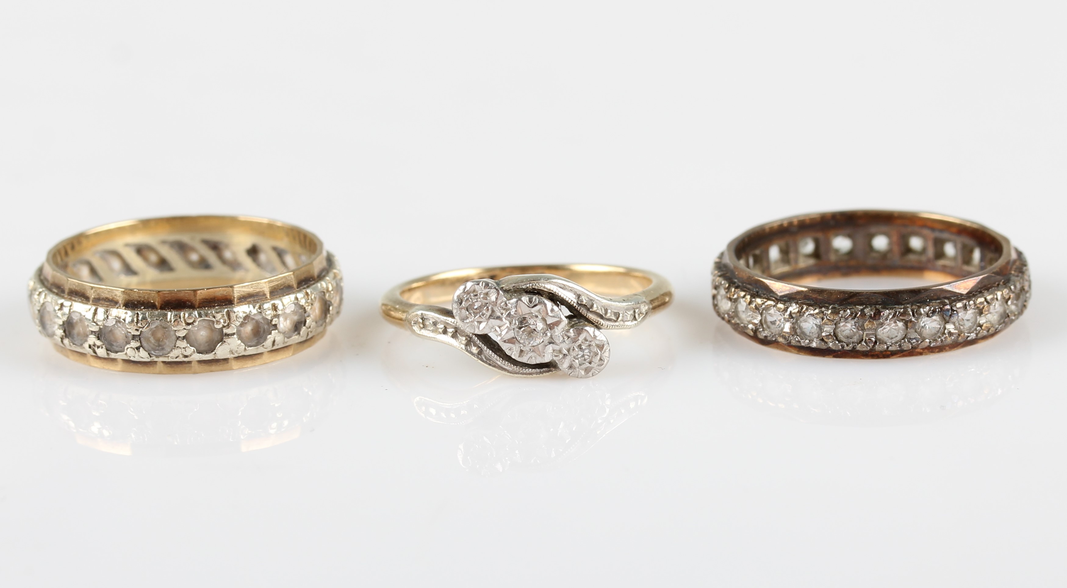 A collection of rings, to include a three stone diamond cross over design ring, stamped 9ct PLAT,