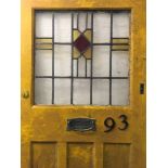 A yellow painted door, with red, yellow and lead glass panel, marked 93.