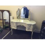 A cream and gilt triple mirrored dressing table with a pair of bedside table and stool.