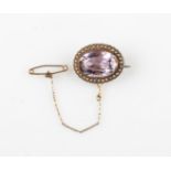 An amethyst and seed pearl brooch, set with an oval cut amethyst, measuring approx. 18x12mm,