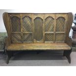 A pine raised back settle with panel back, height 146.5cm, width 183.5cm, depth 47cm.