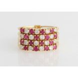 A ruby and diamond four band ring, each band comprising alternating round brilliant cut diamonds and