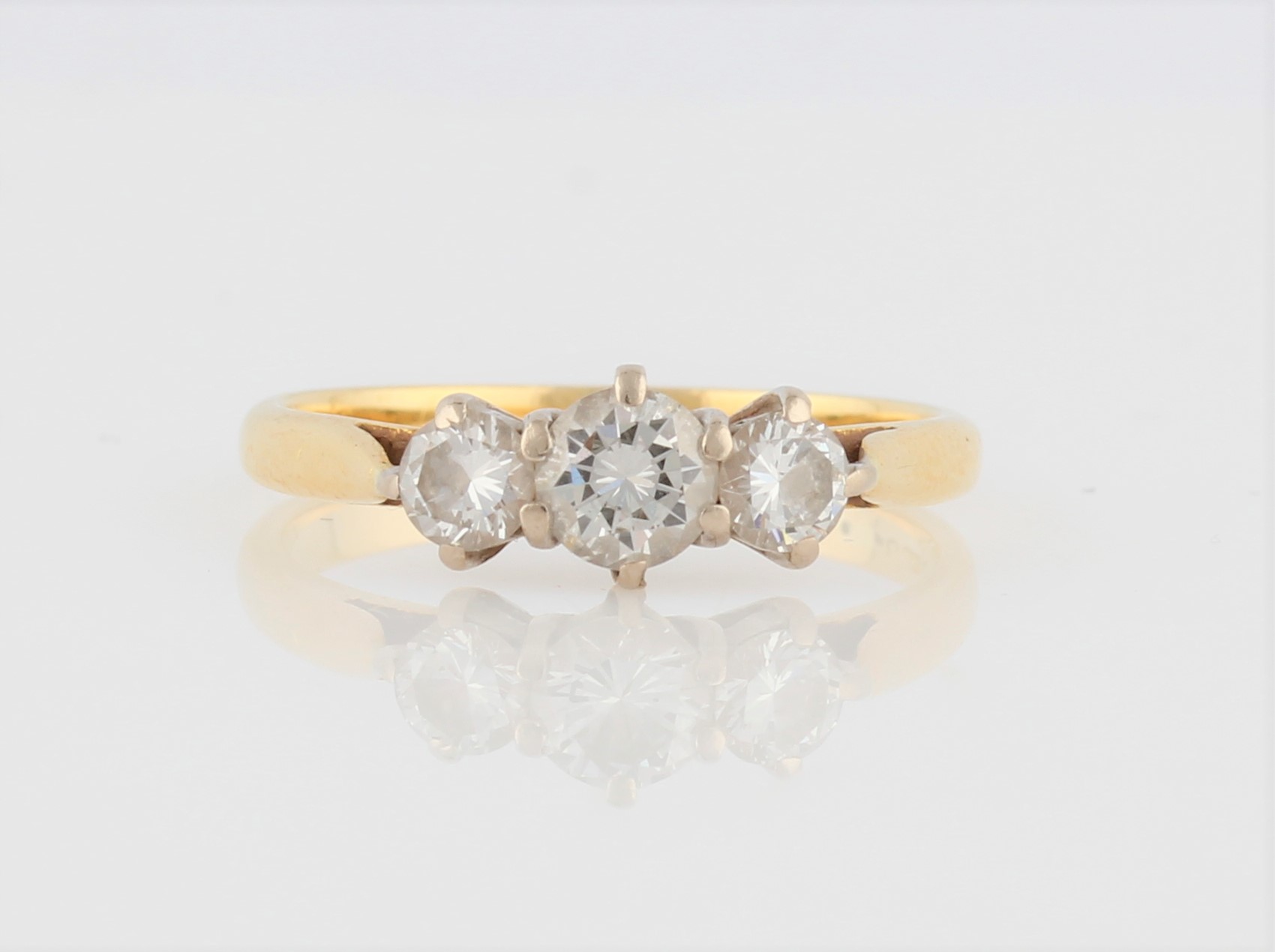 A hallmarked 18ct yellow gold three stone diamond ring, set with three graduated round brilliant cut