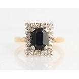 A hallmarked 18ct yellow gold sapphire and diamond cluster ring, set with an emerald cut sapphire