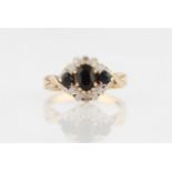 A hallmarked 9ct yellow gold sapphire and diamond ring, set with a central oval cut sapphire