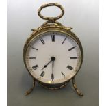 A round brass small mantel clock with an enamelled small Roman numeral face, finished in a wrapped