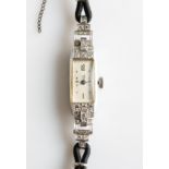 An Art Deco diamond set wrist watch, the rectangular dial set to either side with eight-cut