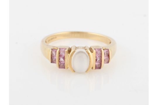 A hallmarked 9ct yellow gold moonstone and pink sapphire ring, set with central oval moonstone