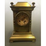 A solid brass cased mantel clock with column design, four finials to top, 21.5cm x 14.5cm x 12.5cm.