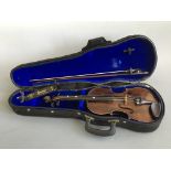 A violin with bow and shoulder rest in blue velvet upholstered case.