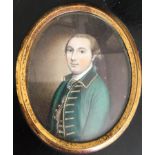 A late 18th Century miniature oil of a gentleman wearing a green and gold jacket painted on ivory.