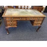 A Hobbs and Co. London mahogany five drawer desk sitting on four carved cabriole legs, claw and ball