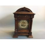 A mahogany cased table clock with fluted column sides.
