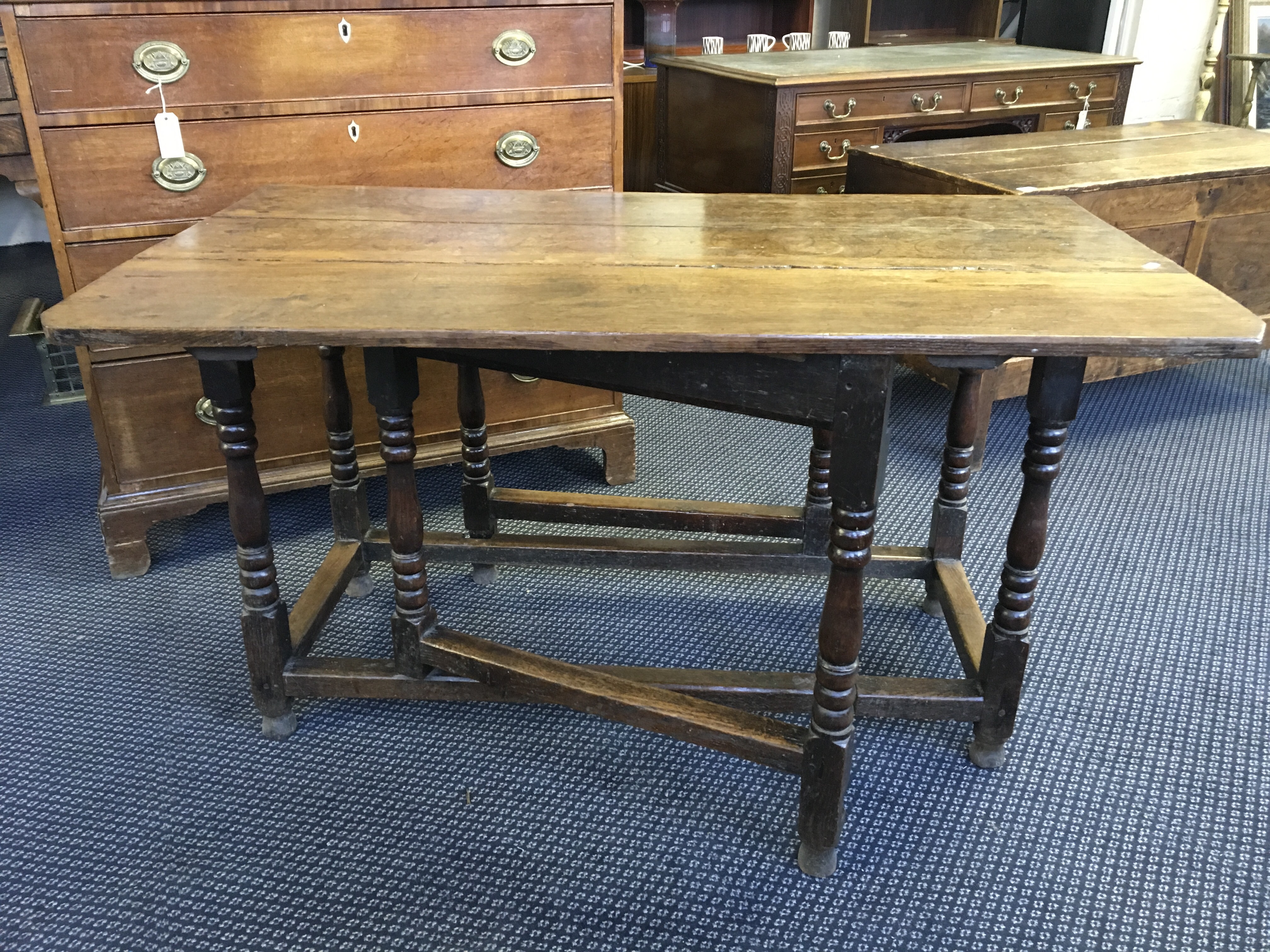 A 18th Century oak, gate legged, peg joint drop leaf table with turned columns