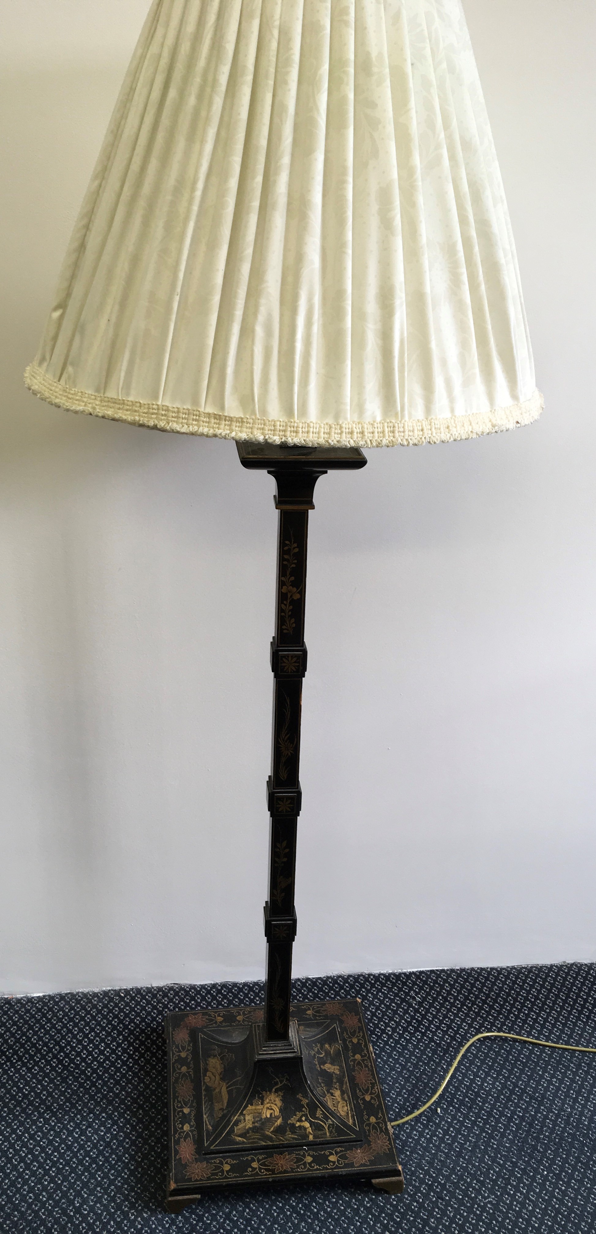 A black and gold painted standard lamp with Japanese scenes and cream shade.