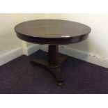 A mid 19th Century small mahogany round tilt topped table on single column base and bun feet, top