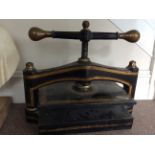 A large turn of the Century black and gilded painted press, with brass handles to T bar.