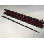 A silver topped and silver collared ebony presentation conductors baton in presentation box with red