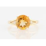 A hallmarked 9ct yellow gold citrine dress ring, set with a central round cut citrine, flanked to