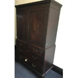 A mahogany two door linen press with two long and two short drawers to base and brass handles.