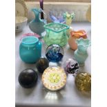 A group of various coloured glass to include paperweights, vases etc.