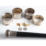 A lot to include four hallmarked silver napkin rings, a walking stick with white metal handle, a