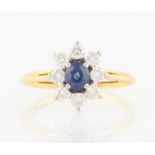 A hallmarked 18ct yellow gold sapphire and diamond cluster ring, set with a central oval cut