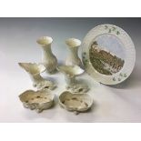 A selection of Belleek items to include a plate depicting the original factory, a pair of pink and