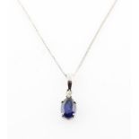 A synthetic sapphire and diamond pendant, set with a central oval cut synthetic sapphire,