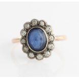 A blue paste and diamond cluster ring, set with a central oval cut blue paste surrounded by a border