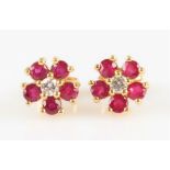 A pair of ruby and diamond flower design cluster earrings, each set with a central round brilliant