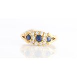 A sapphire and diamond cluster ring, set with three round cut sapphires, the central sapphire