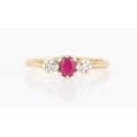 A hallmarked 9ct yellow gold ruby and diamond three stone ring, set with a central oval cut ruby,