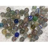 Early handmade glass marbles, various colours and sizes in red metal toffee tin, approximately