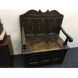 A late 18th Century converted blanket box with a raised three panelled earlier back and arms oaks