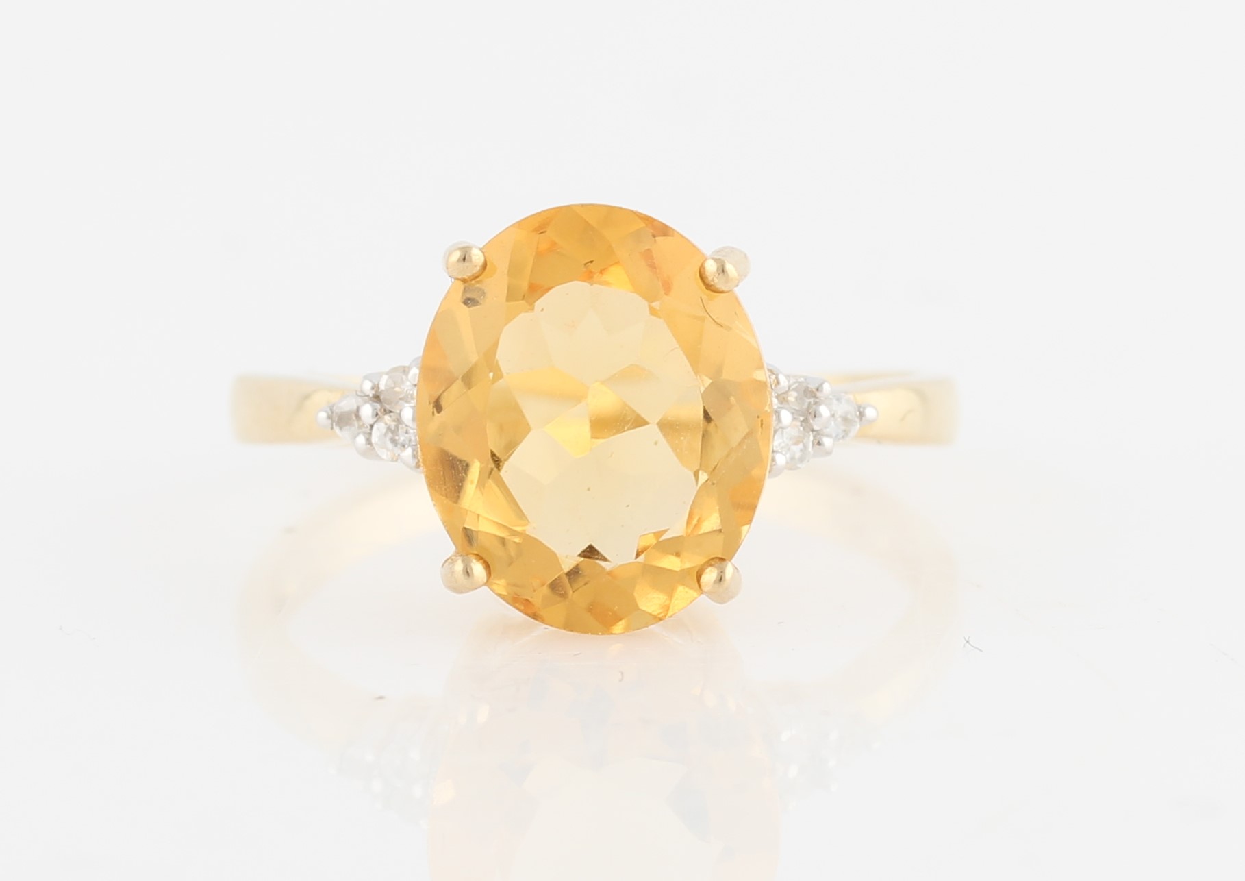 A hallmarked 9ct yellow gold citrine dress ring, set with a central oval cut citrine, with round cut