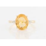 A hallmarked 9ct yellow gold citrine dress ring, set with a central oval cut citrine, with round cut