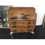 A Northampton cabinet company mahogany bureau with Japanese scenes to front and three drawers.