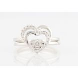 A hallmarked 9ct white gold diamond two ring set, one ring in heart open metalwork diamond set