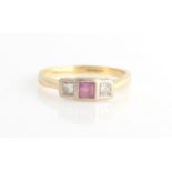A hallmarked 18ct yellow gold pink sapphire and diamond three stone ring, set with a central