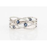 A sapphire and diamond band ring, the open metalwork cross over design set with eight-cut diamond