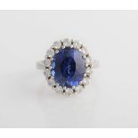 A synthetic sapphire and cubic zirconia cluster ring, set with a central oval cut synthetic sapphire