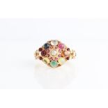 A multi gemstone cluster ring, the open metalwork tiered design set with various facetted and