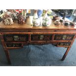 A Chinese distressed wooden dresser base with five drawers, carved flower decoration and metal