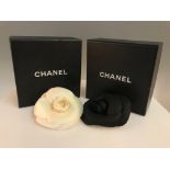 A CHANEL off white Camelia flower brooch in box, together with a CHANEL black Camelia flower