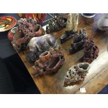 A group of oriental soapstone carvings of animals, people and flowers.