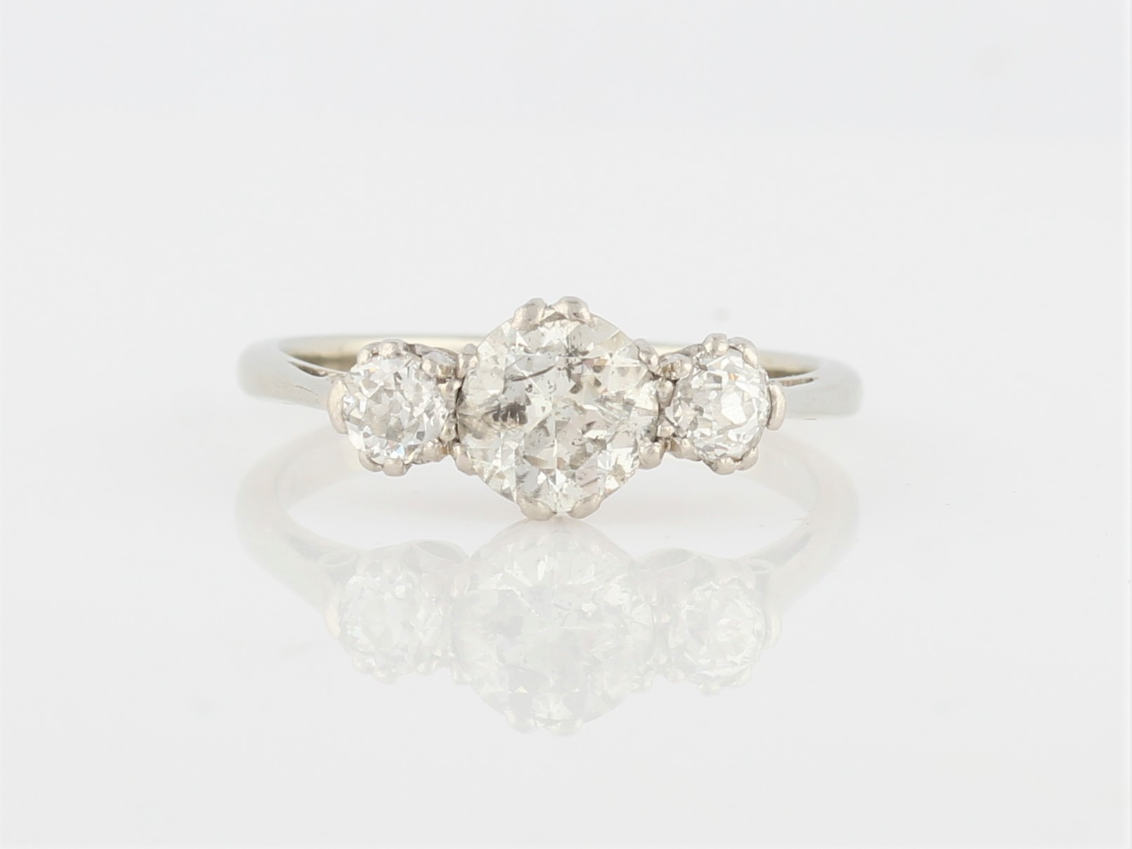 A three stone diamond ring, set with three graduated round cut diamonds, the central diamond being a