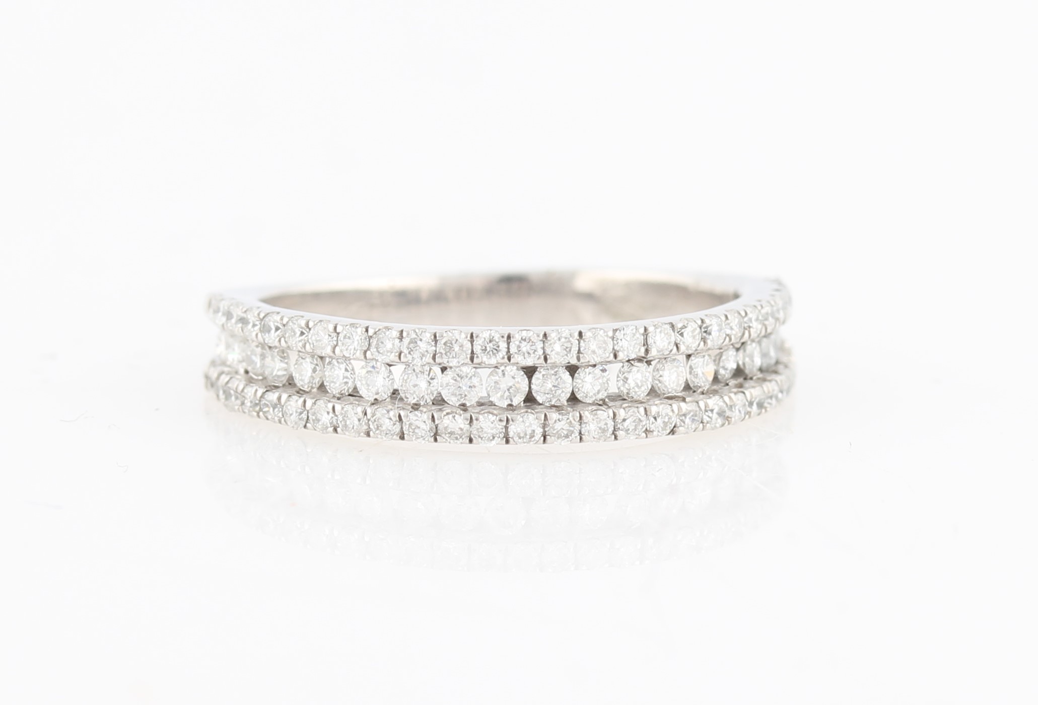 A diamond half eternity ring, set with three rows of round brilliant cut diamonds, unmarked white