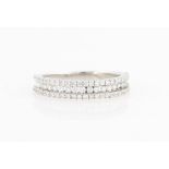 A diamond half eternity ring, set with three rows of round brilliant cut diamonds, unmarked white
