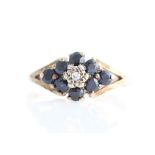 A hallmarked 9ct yellow gold sapphire and diamond cluster ring, set with a central eight-cut diamond